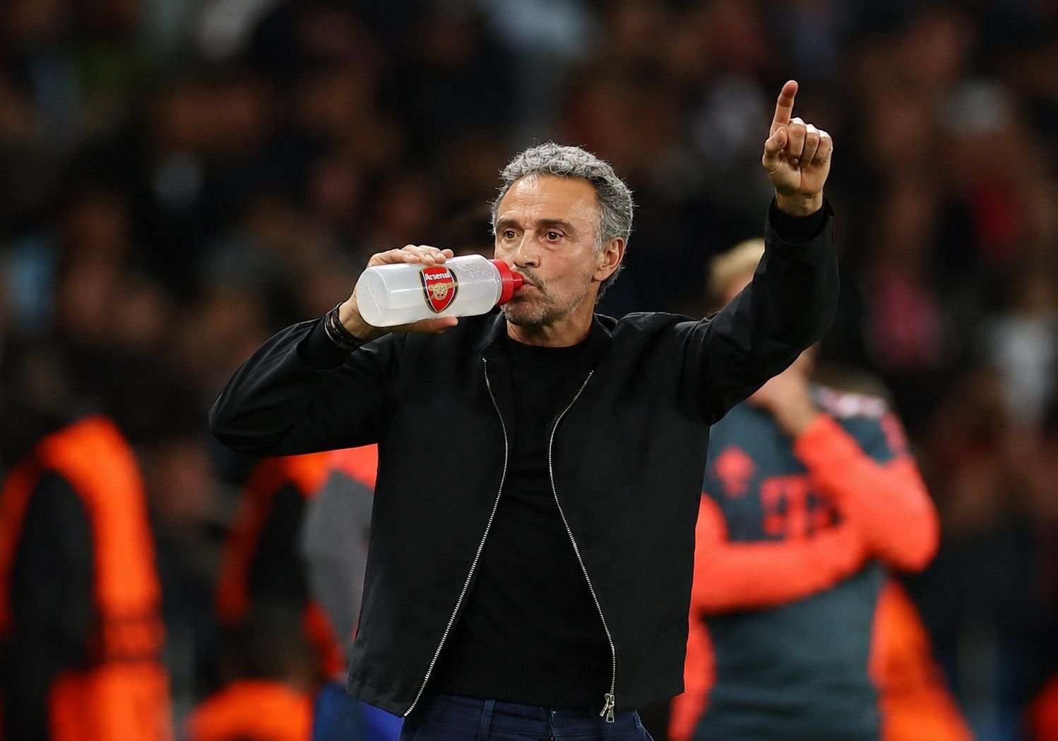 Football manager drinking from an Arsenal bottle